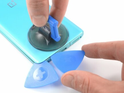 Вставьте второй инструмент для вскрытия под левым нижним углом.